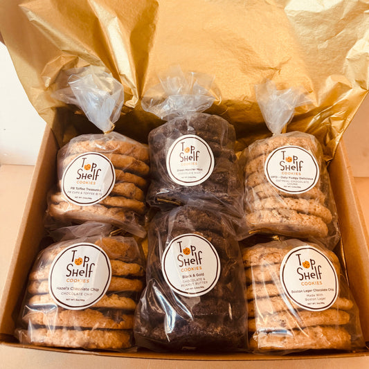 Box of assorted cookies with 'Top Shelf' branding on a light background