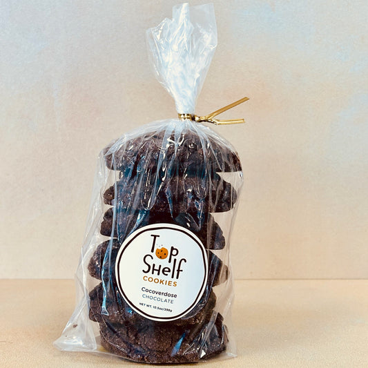 A clear plastic package containing chocolate cookies with a label that reads 'Top Shelf Cookies - Cocoverdose Triple Chocolate'.