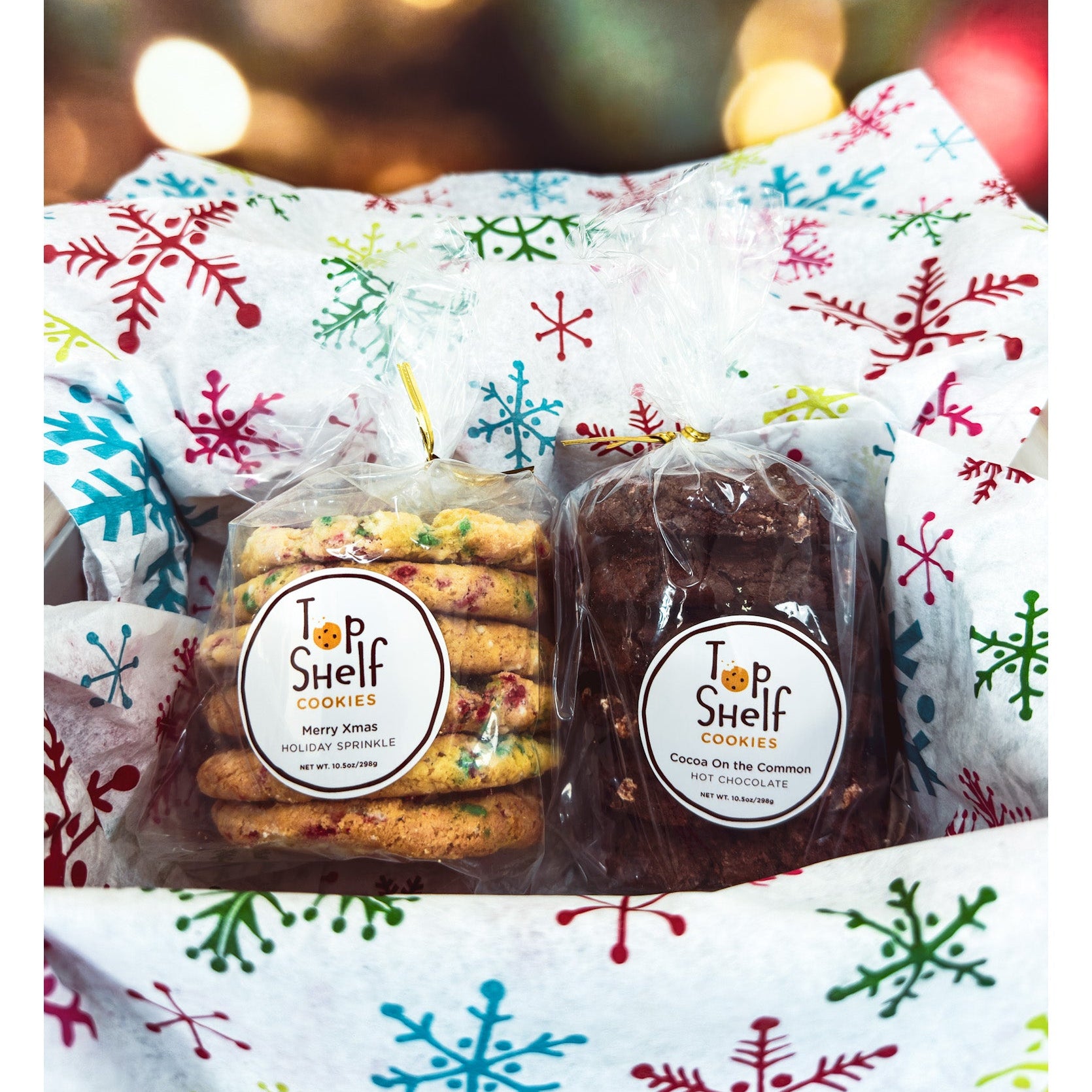 Two packages of cookies labeled 'Top Shelf Cookies' on a festive background with snowflakes.