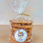 A pack of S'Mores cookies wrapped in a transparent plastic bag with a gold-colored twist tie on top. The packaging has a brown label with the brand 'Top Shelf Cookies' and the product name 'S'Mores'.