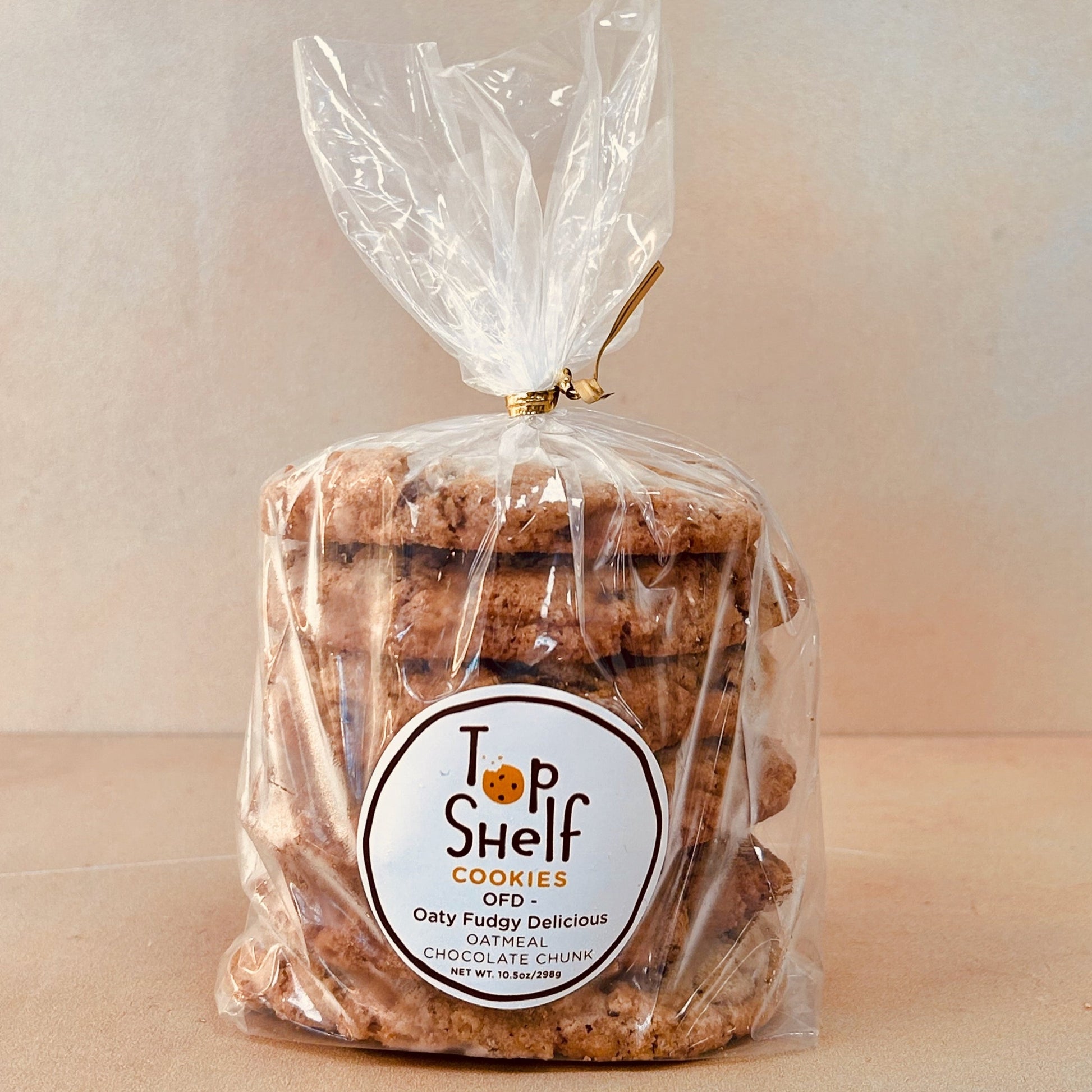 Packaged cookies labeled 'Top Shelf Cookies - Oaty Fudgy Delicious' in a clear plastic bag tied with a ribbon.