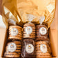 Box of bagged snacks with 'Top Shelf' labels on a neutral background