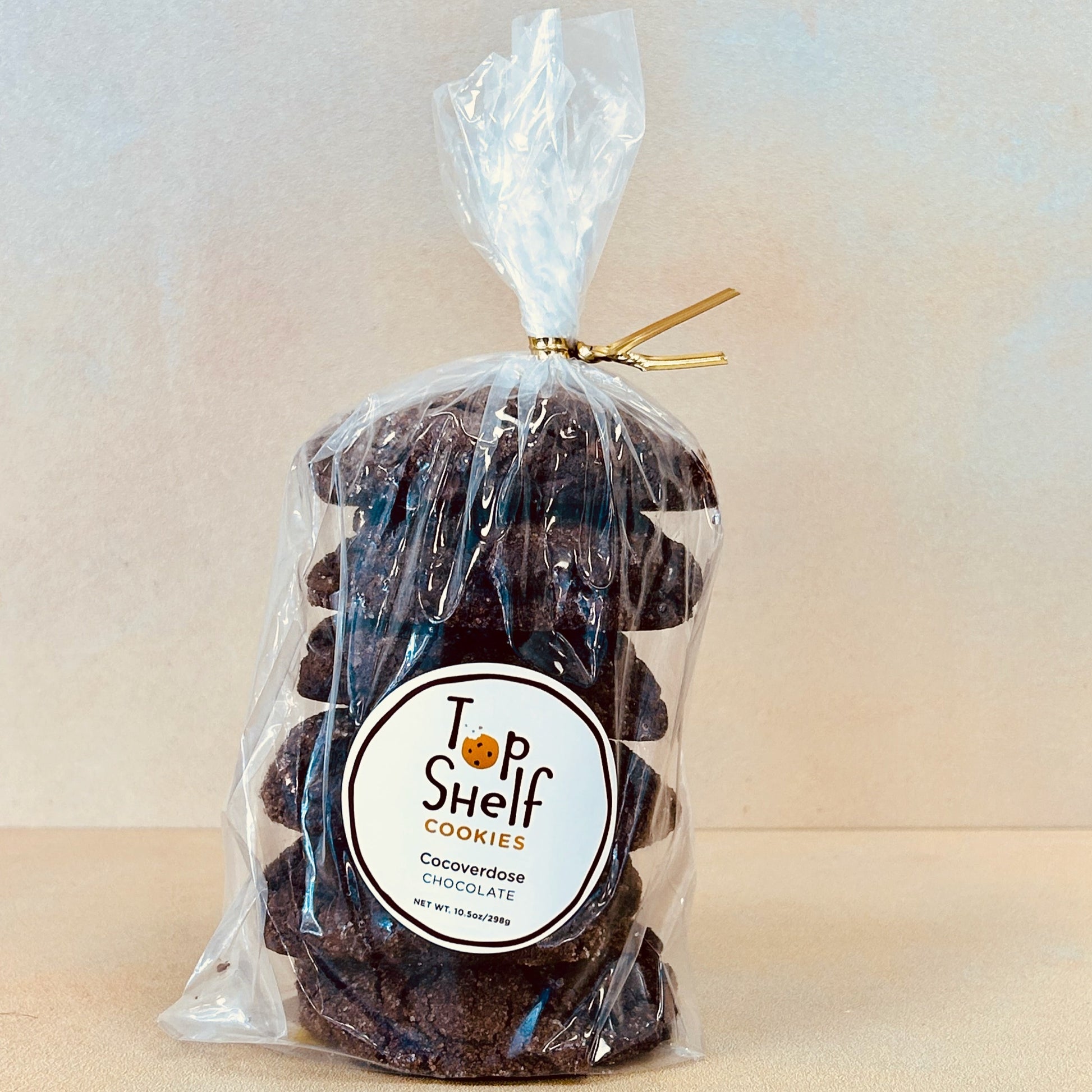 A clear plastic package containing chocolate cookies with a label that reads 'Top Shelf Cookies - Cocoverdose Triple Chocolate'.